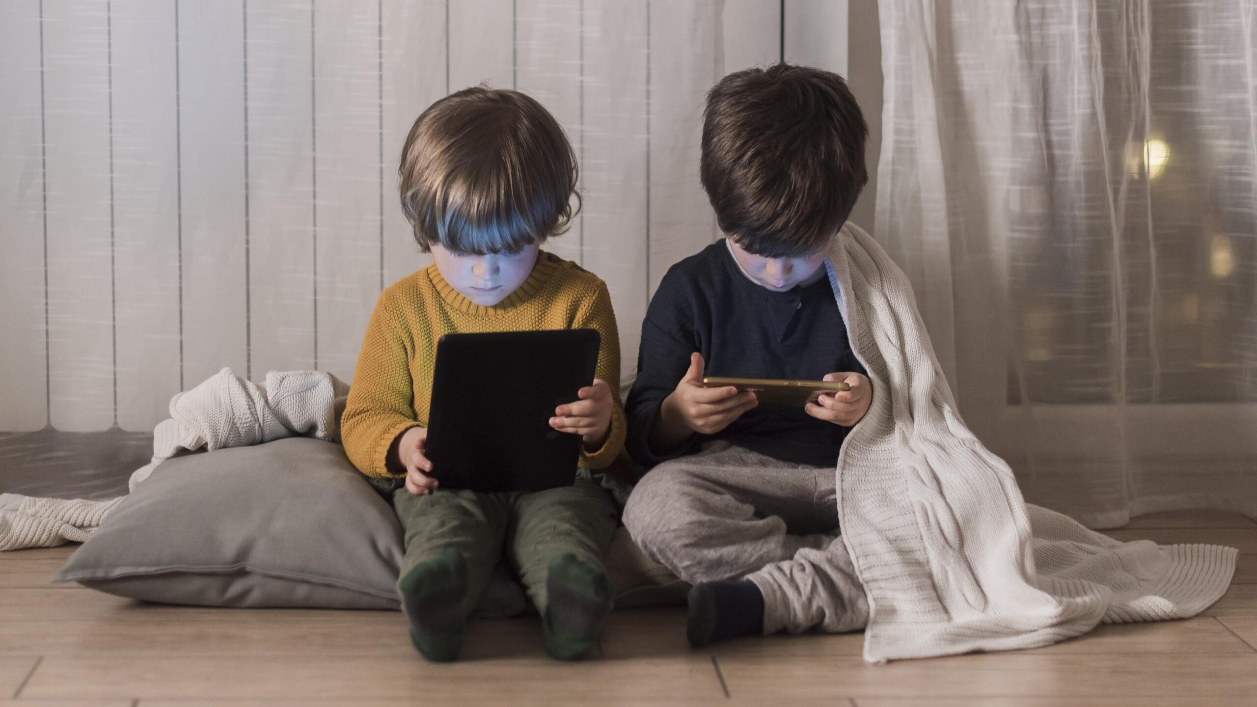 niños-pantallas Niños usando dispositivos electrónicos juntos.